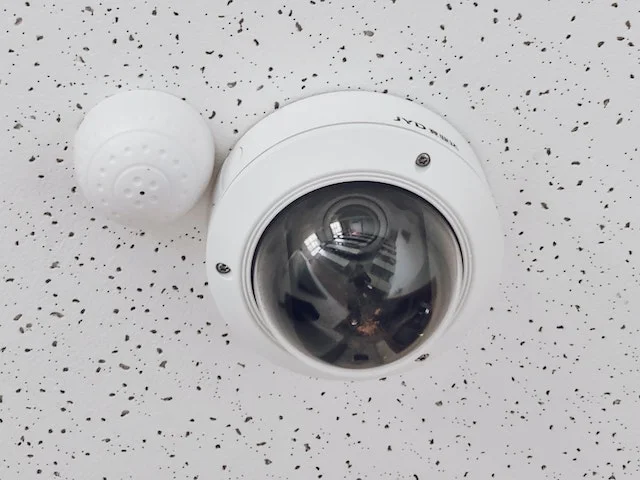 CCTV camera installed in a room with white ceiling.