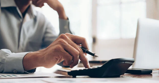 Man pushing numbers into a calculator to work out costs.