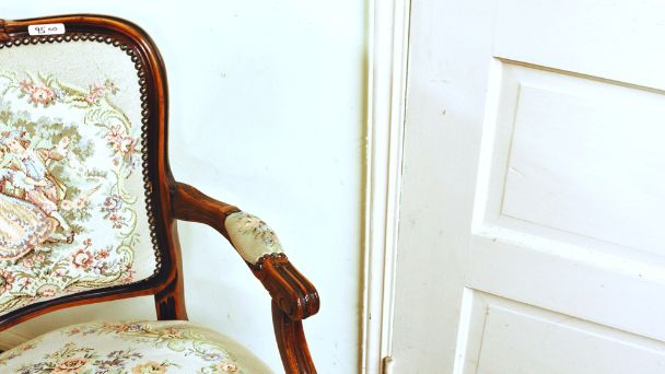 An old chair placed near a white door.